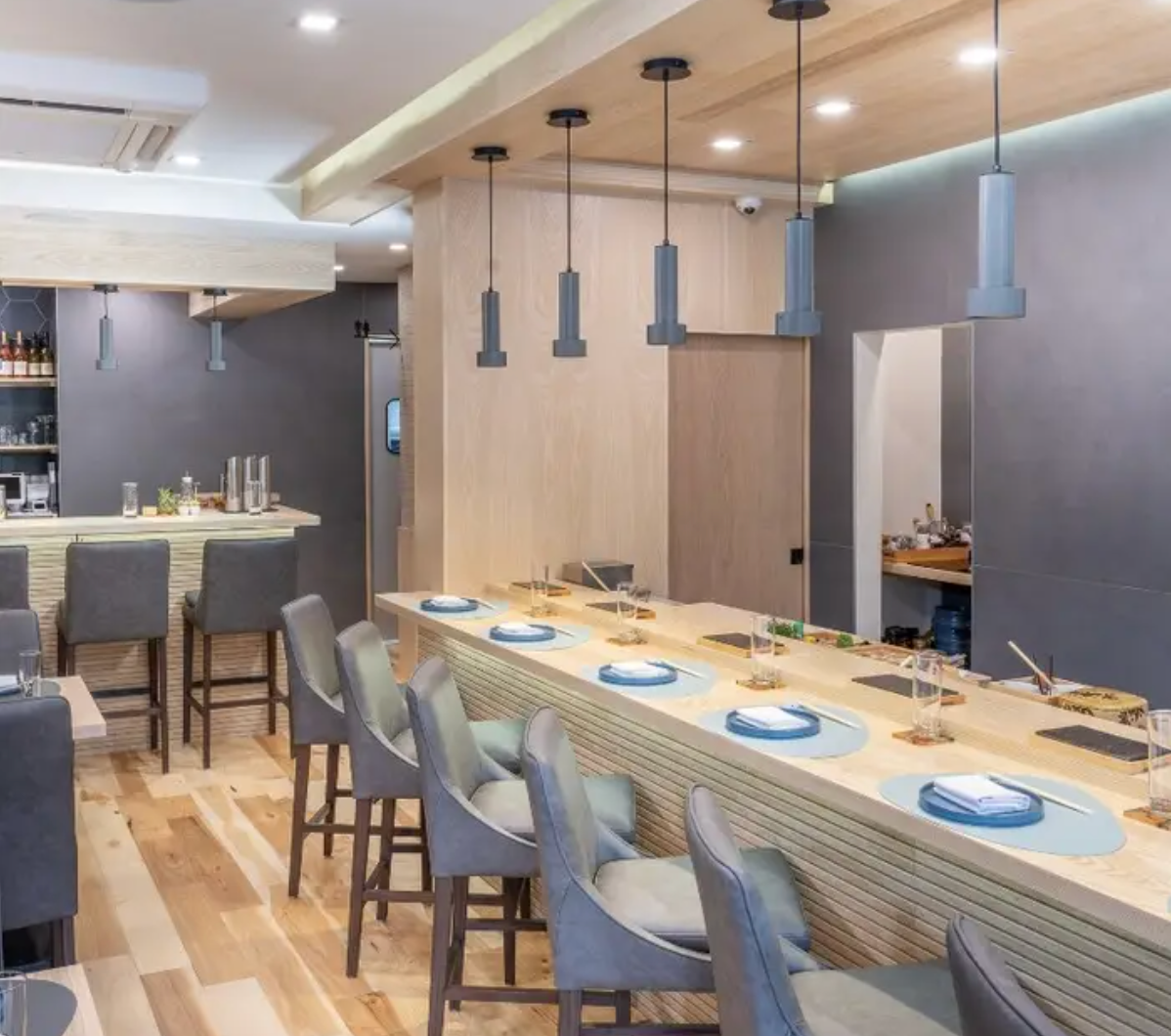 Modern restaurant interior with long wooden bar and gray chairs