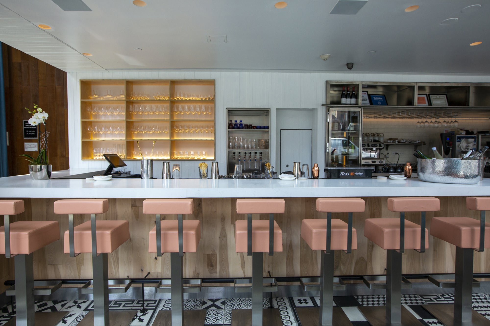 Modern bar with pink stools and a well-lit backbar.