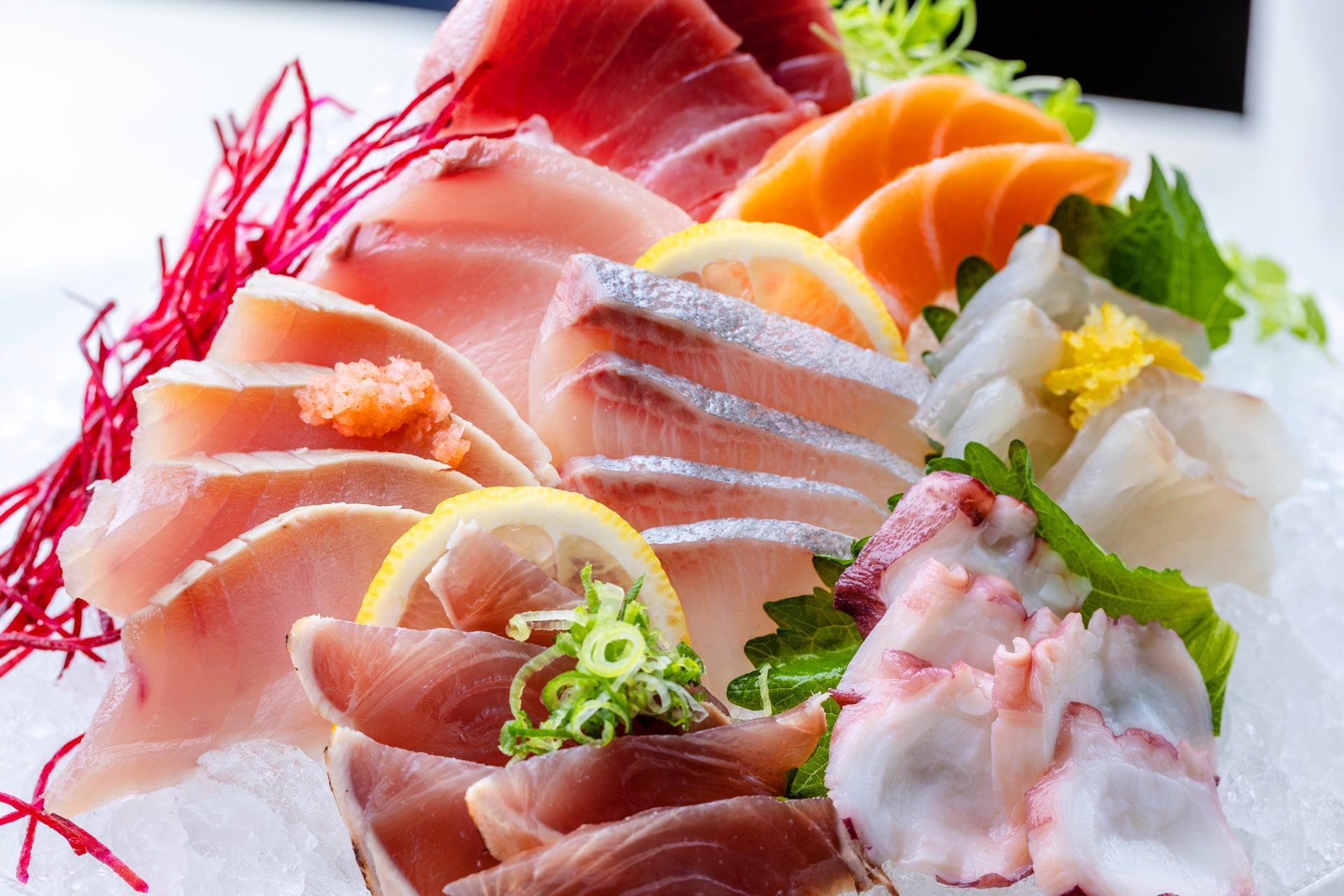 Assorted sashimi on a bed of ice with lemon and wasabi.