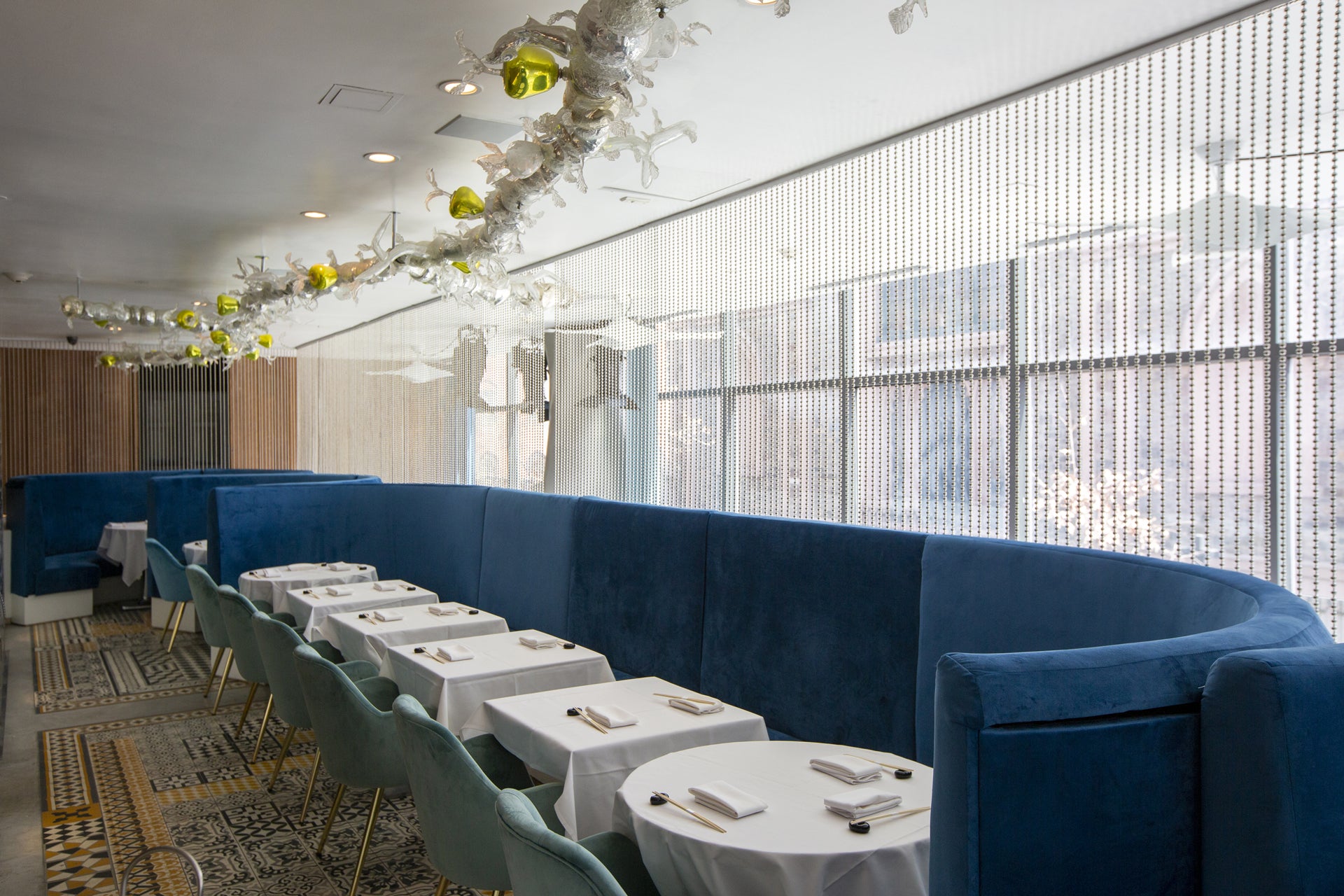 Momoya SoHo restaurant interior with blue booths, white tables, and large windows.