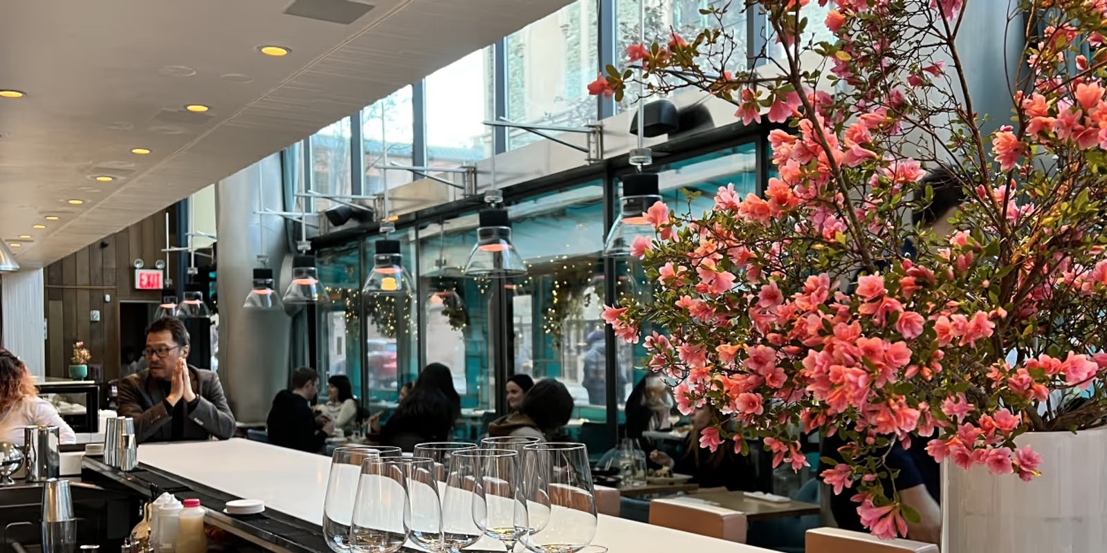 Dining area with tables, chairs, and a large floral arrangement.
